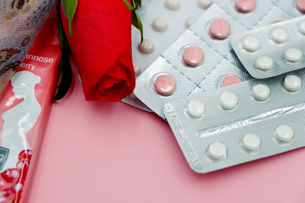 pexels photo 18806858 18806858 Pills and red rose on pink background, symbolizing healthcare and romance.