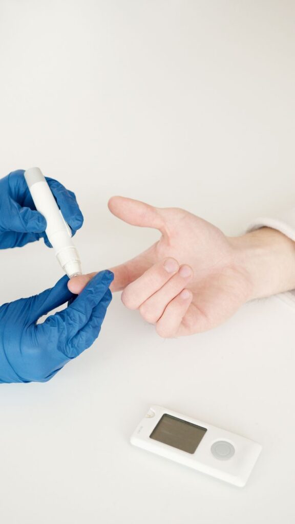 pexels photo 6823410 6823410 A healthcare professional tests blood sugar with a glucometer and lancet pen in a medical setting.